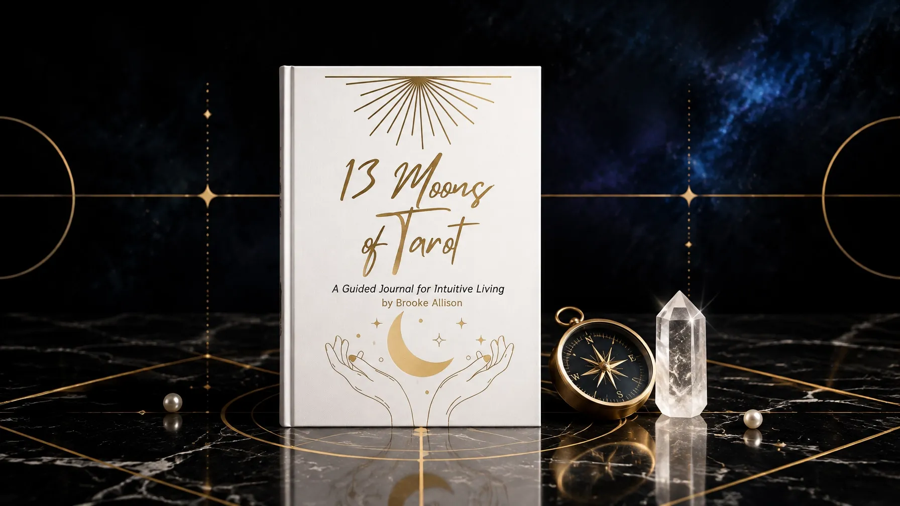 The 13 Moons of Tarot Journal closed on dark marble beside a gold compass and quartz point